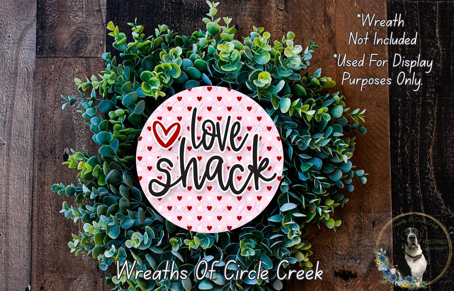 a wreath made of green leaves and a pink circular sign with the text "Love Shack" written on it.