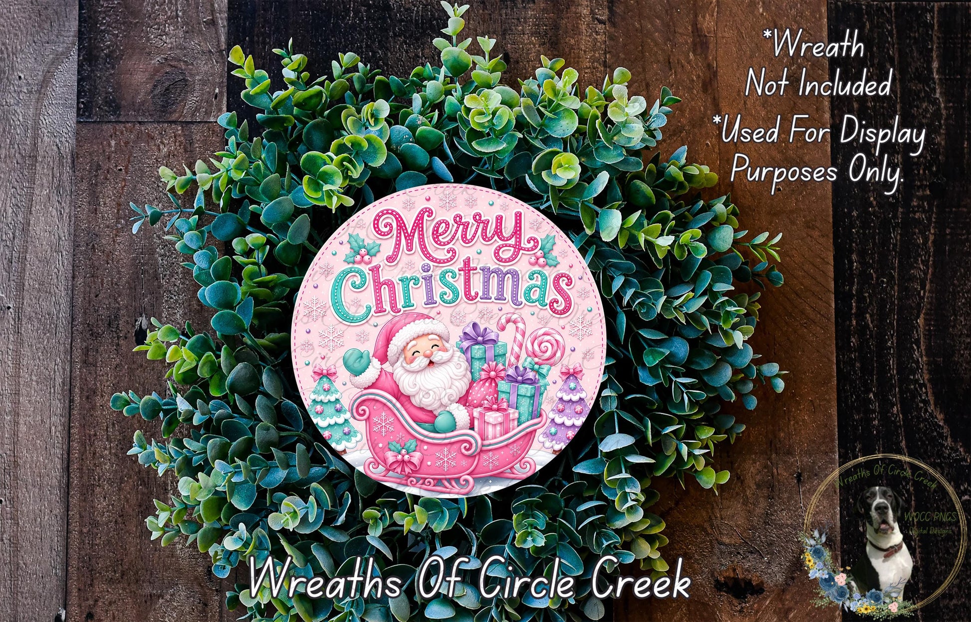 A Christmas wreath made of green foliage and featuring a Santa Claus illustration. The wreath is displayed on a wooden surface, and there is a text overlay that reads "Merry Christmas" and "Wreath Not Included * Used For Display Purposes Only".