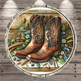 A pair of brown cowboy boots with intricate designs, surrounded by flowers, leaves, and other natural elements, all set against a rustic wooden background.