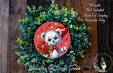 A wreath made of green leaves and red flowers, with a cute white teddy bear wearing a red bow tie and holding a bouquet of red roses.
