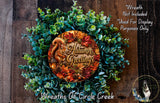 a wreath made of various autumn-themed elements, including a squirrel, leaves, pine cones, and berries, with the text "Autumn Greetings" displayed on it.