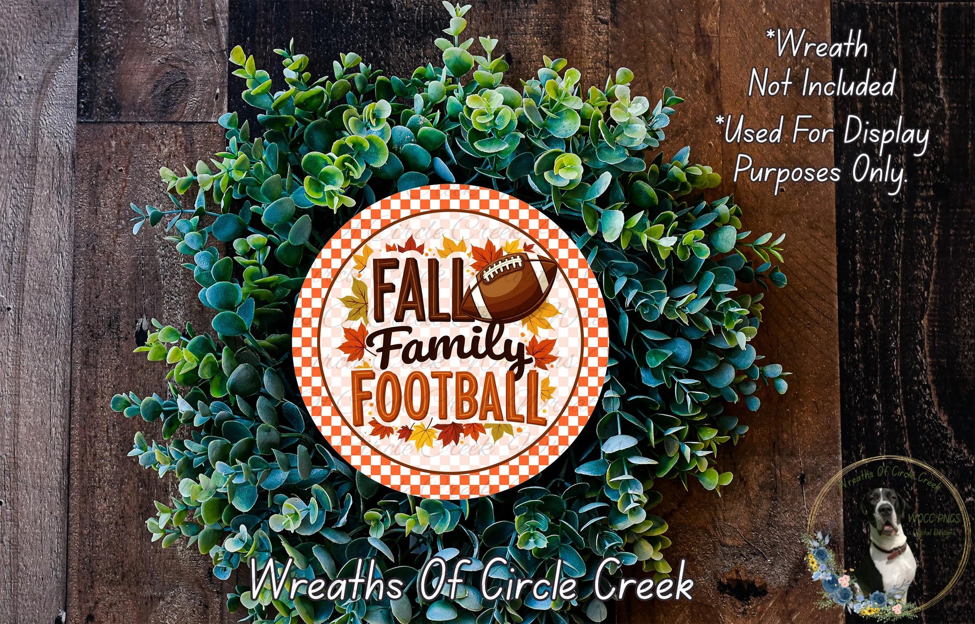 a wreath made of green leaves and a football, with the text "FALL Family Football" displayed on it. The wreath is placed on a wooden surface, and there is a small dog in the bottom right corner of the image.