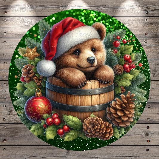 A brown bear wearing a Santa hat is sitting in a wooden barrel surrounded by Christmas decorations, including pine cones, berries, and a star.