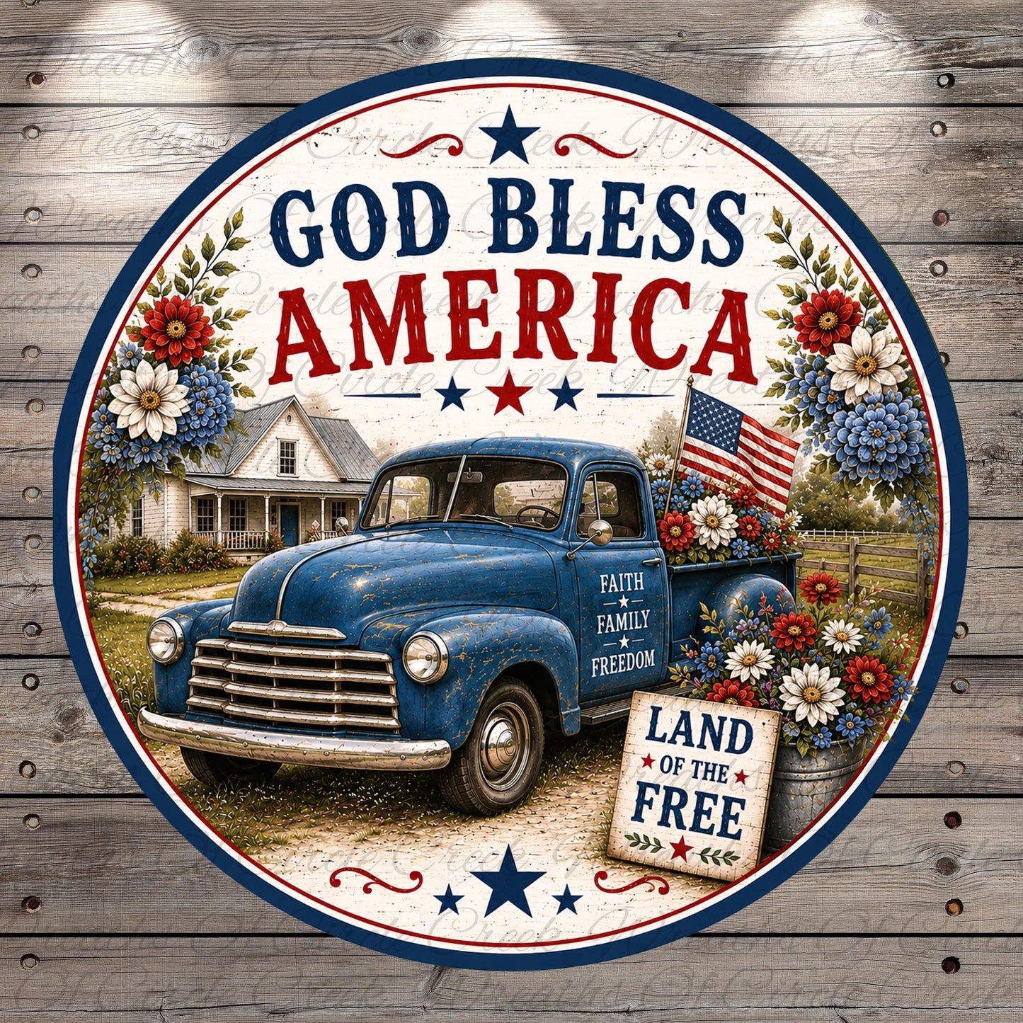 A circular patriotic sign with a blue vintage truck, flowers, and an American flag, along with the text "God Bless America" and "Land of the Free".