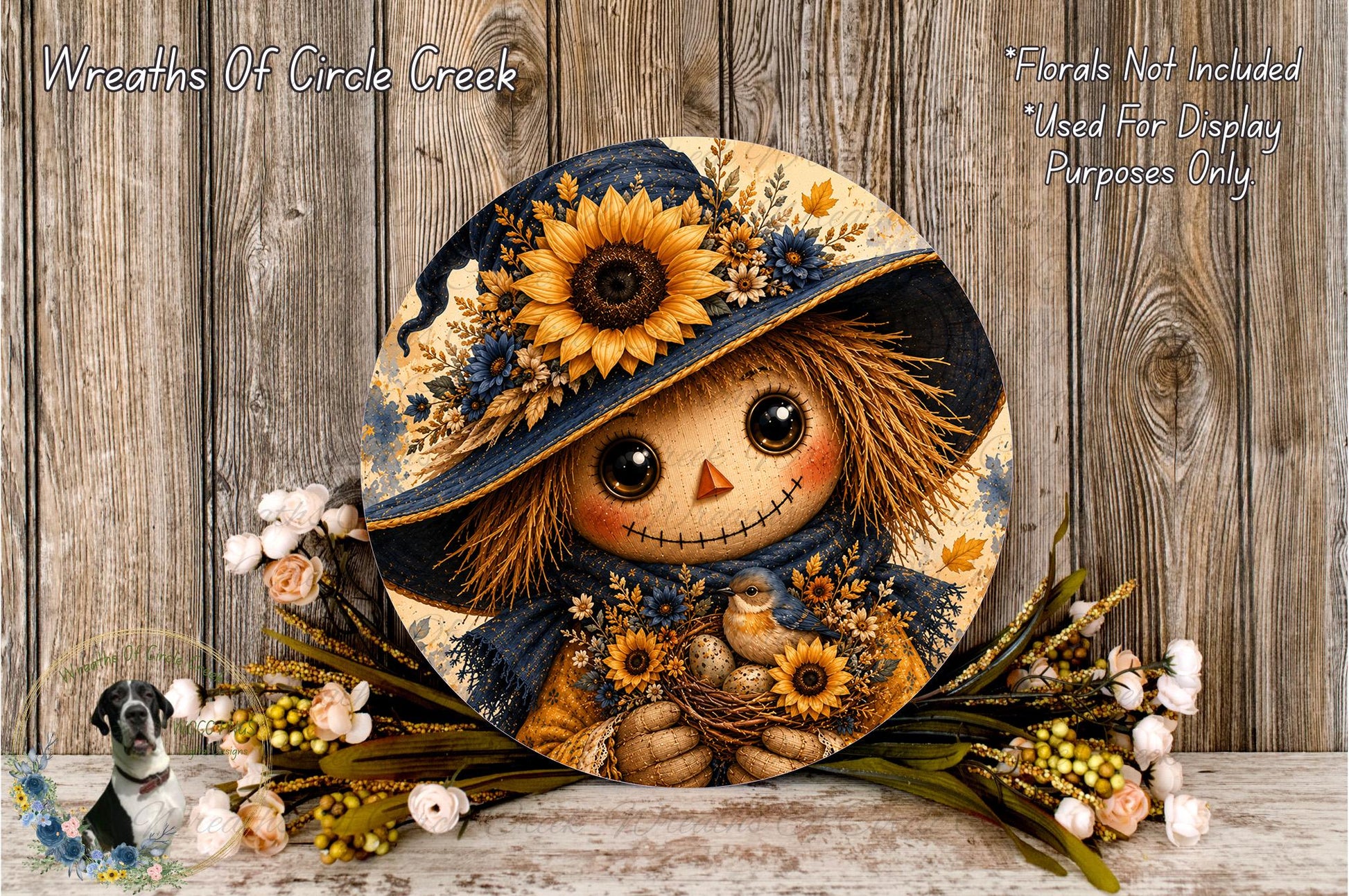 A round decorative piece featuring a scarecrow-like figure with a sunflower hat and floral accents, surrounded by a wreath of flowers and greenery.