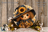 A round decorative piece featuring a scarecrow-like figure with a sunflower hat and floral accents, surrounded by a wreath of flowers and greenery.