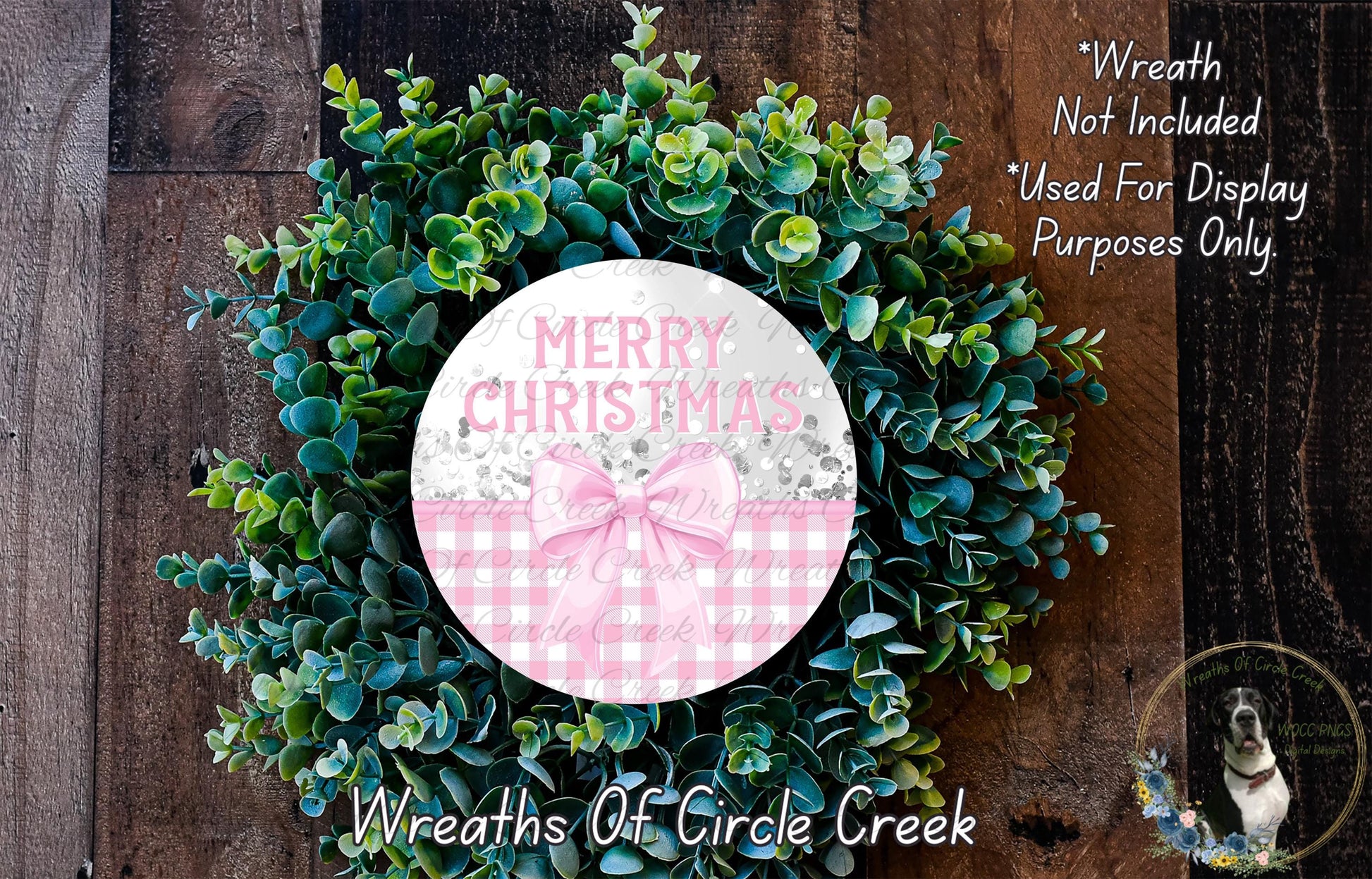 A wreath made of green leaves and a pink bow, with the text "Merry Christmas" displayed on it.