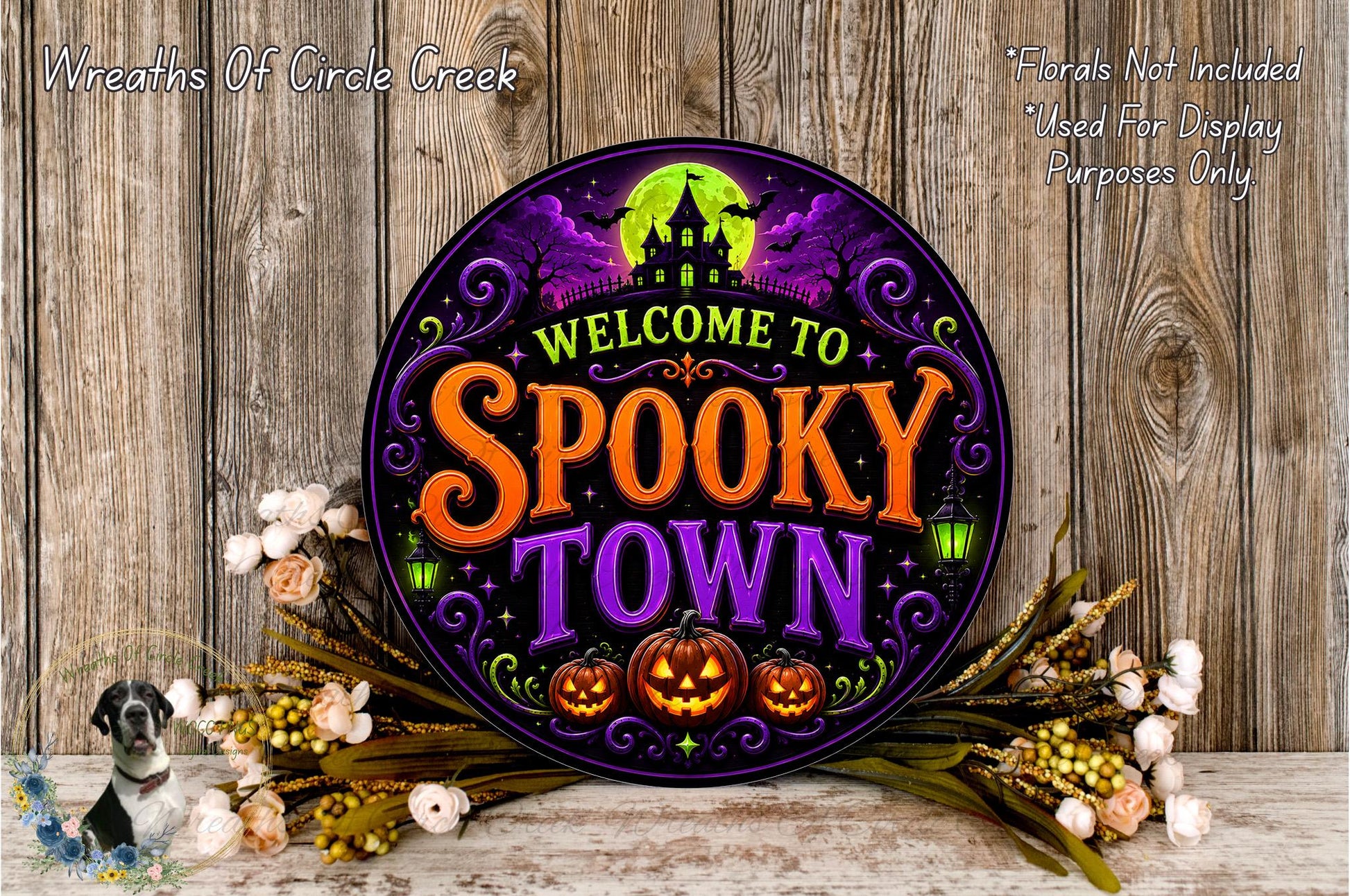 a Halloween-themed sign that reads "Welcome to Spooky Town", surrounded by a floral arrangement and pumpkins.