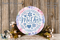 a decorative sign with the text "Beautiful Graceful Mother" surrounded by flowers and greenery. The sign is placed on a wooden surface, and there is a small dog in the background.