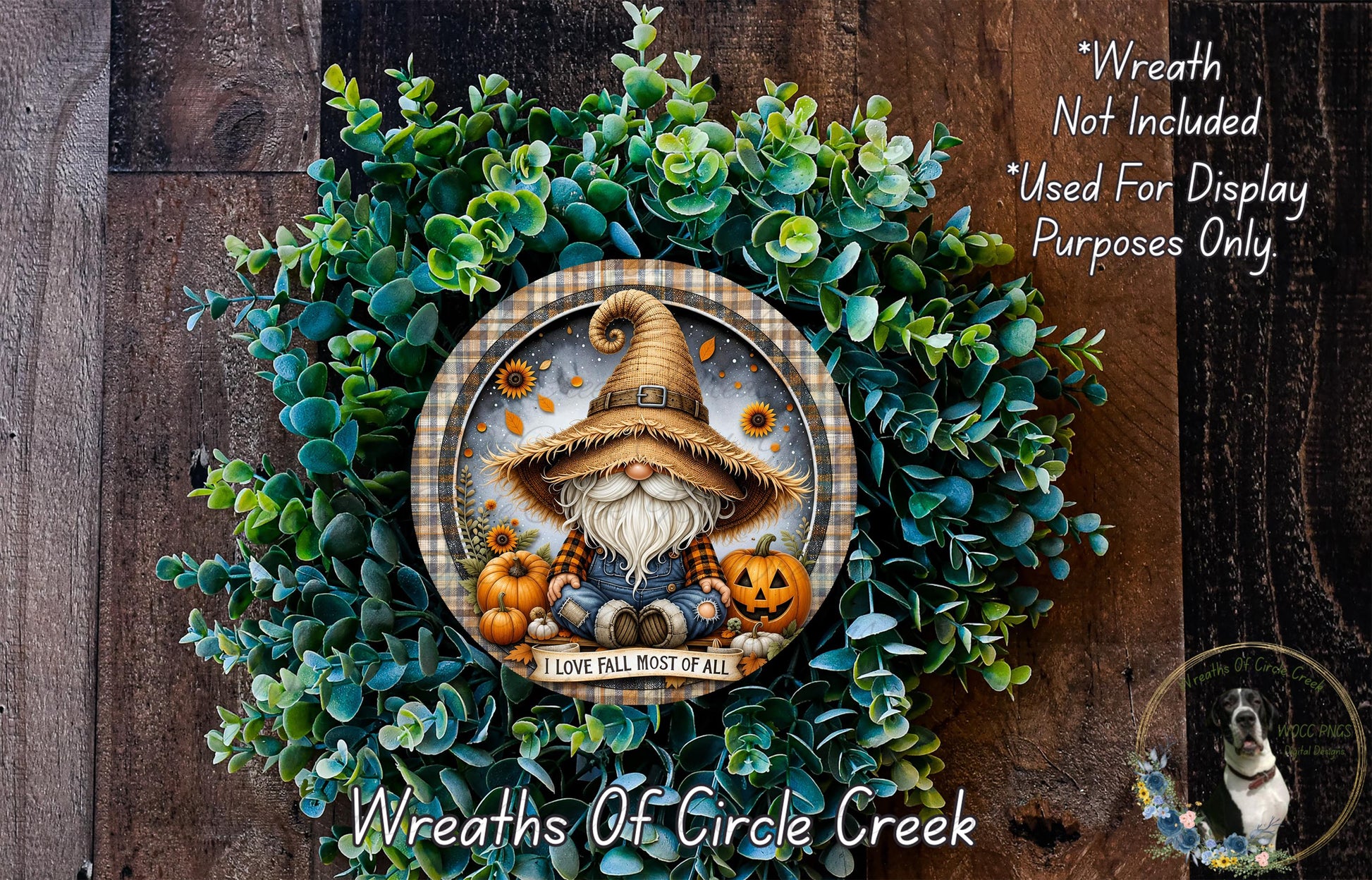 a wreath with a gnome wearing a hat and holding a pumpkin, surrounded by green foliage. The wreath is placed on a wooden surface, and there is a small dog in the bottom right corner of the image.