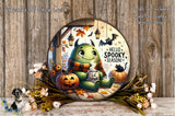 A whimsical illustration of a green monster with horns and a scarf, sitting on a wooden surface surrounded by autumn decorations such as pumpkins, leaves, and flowers. The monster appears to be holding a mug with the text "Hello Spooky Season!" written on it.
