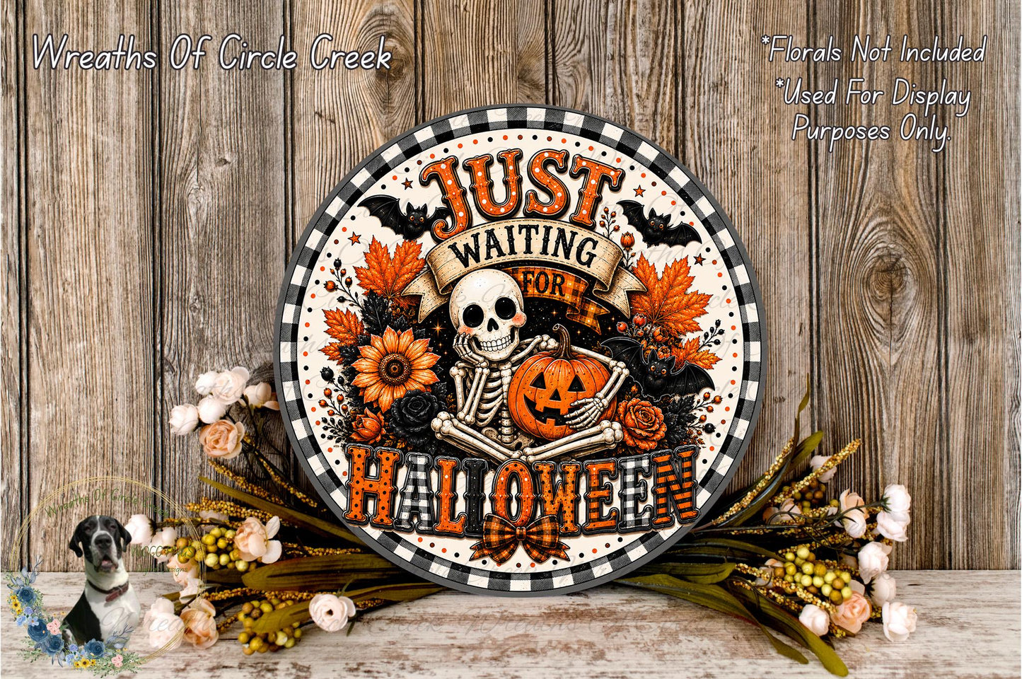 A Halloween-themed sign with a skeleton holding a jack-o-lantern, surrounded by autumn flowers and leaves, placed on a wooden surface.