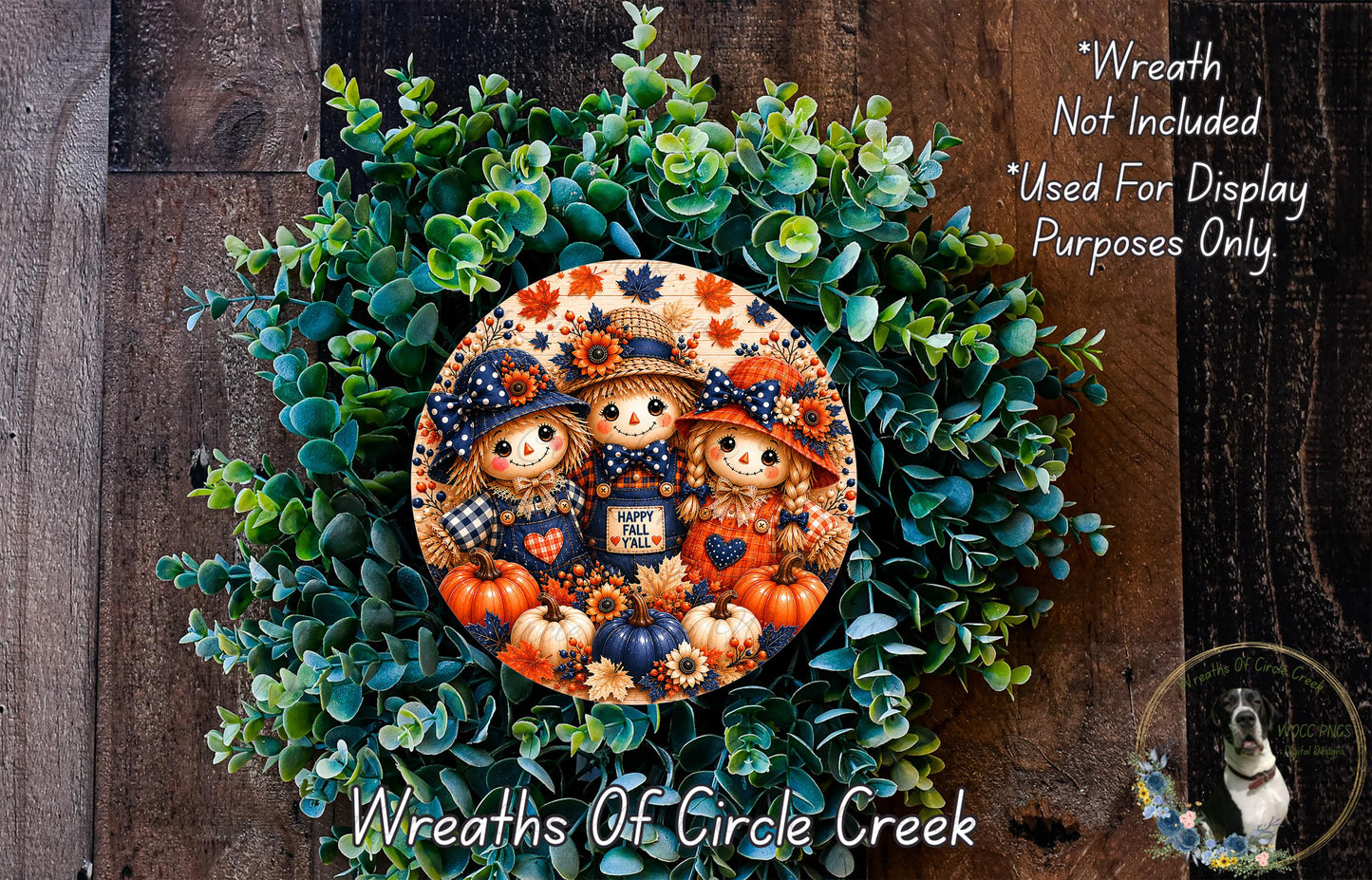 a wreath with a central design of three scarecrow characters surrounded by various fall-themed elements such as pumpkins, leaves, and flowers. The wreath is set against a backdrop of green foliage and a wooden wall.