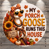 A decorative sign featuring a white goose wearing sunglasses and a bow, surrounded by autumn-themed elements such as sunflowers, pumpkins, and leaves. The sign also includes the text "My Porch Goose Runs This House" and a "Thankful Gracious Blessed" sign.