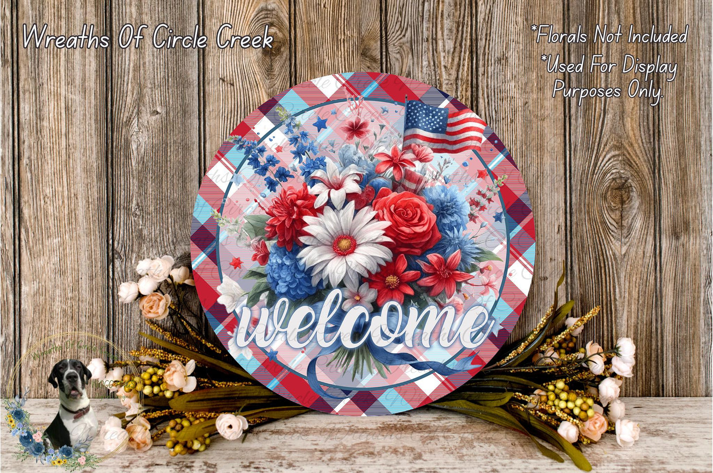 a decorative sign with a patriotic theme, surrounded by flowers and foliage. The sign displays the word "welcome" and includes an American flag design. The background is a rustic wooden wall, adding a warm and inviting atmosphere to the scene.