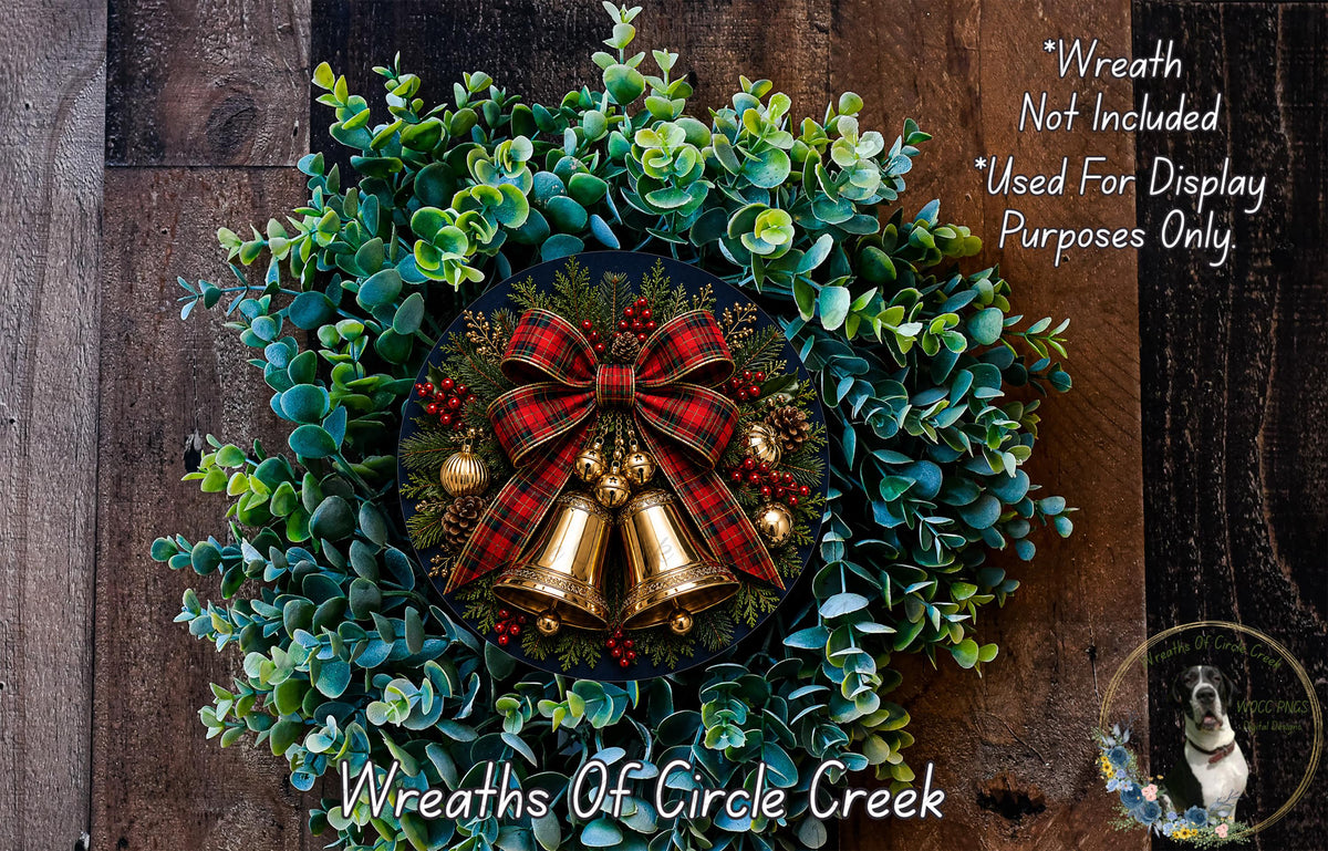 A festive Christmas wreath made of evergreen branches, adorned with a red and black plaid bow, bells, and berries. The wreath is displayed on a wooden wall, and there is a small dog in the bottom right corner of the image.