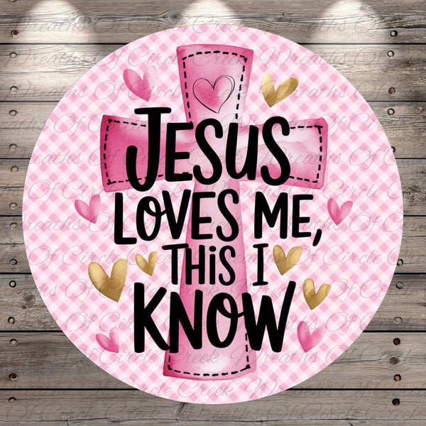 A pink and white checkered background with a large pink cross and the text "JESUS LOVES ME, THIS I KNOW" written on it.