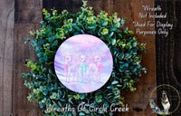 a wreath made of green leaves and a circular design with a purple and pink background, possibly featuring a group of deer or other animals.
