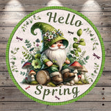 A gnome wearing a green hat and surrounded by mushrooms, flowers, and leaves sits on a log, with the text "Hello Spring" displayed around the gnome.