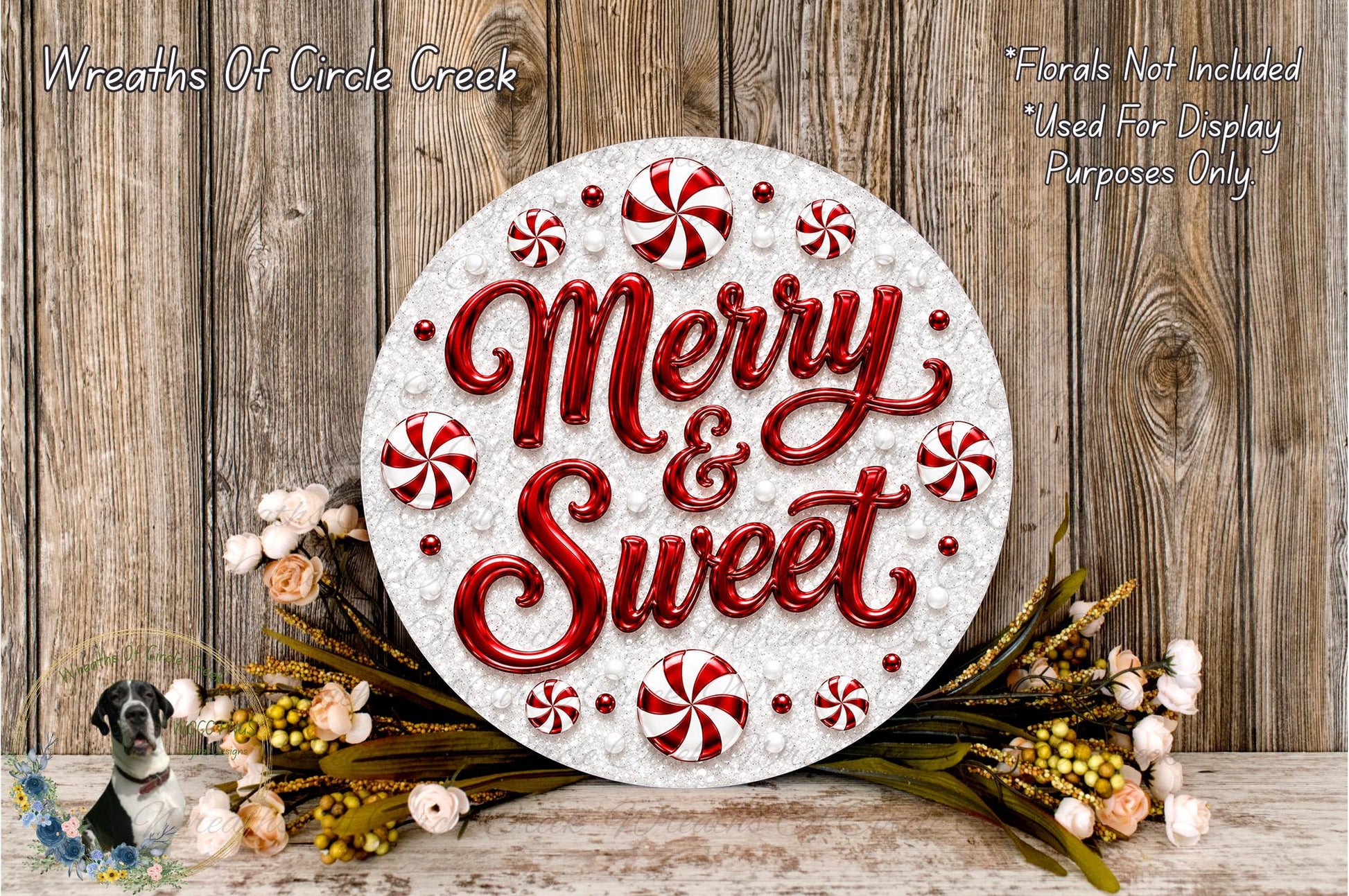 a festive wreath with the text "Merry & Sweet" written on it, surrounded by red and white candy canes and flowers. The wreath is displayed on a wooden surface, and there is a small dog in the background.