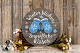 A wooden sign with the text "Winter Wishes & Snowflake Kisses" and a pair of blue snowflake-patterned mittens, surrounded by flowers and greenery.