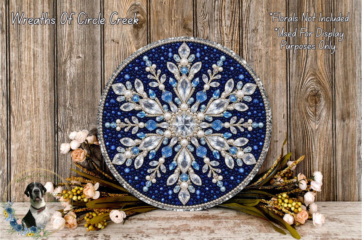 a large, ornate blue and white snowflake-like design with intricate details, surrounded by a variety of flowers and foliage.