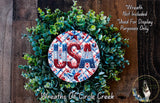 A wreath made of green leaves and a circular design with the word "USA" in red, white, and blue colors.