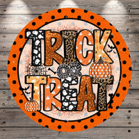 a circular design with the text "TRICK or TREAT" in a bold, orange font. Surrounding the text are various Halloween-themed elements, including a spider web, a leopard print, and two pumpkins. The design has a playful and festive appearance, with the use of orange, black, and white colors creating a visually appealing and eye-catching design.