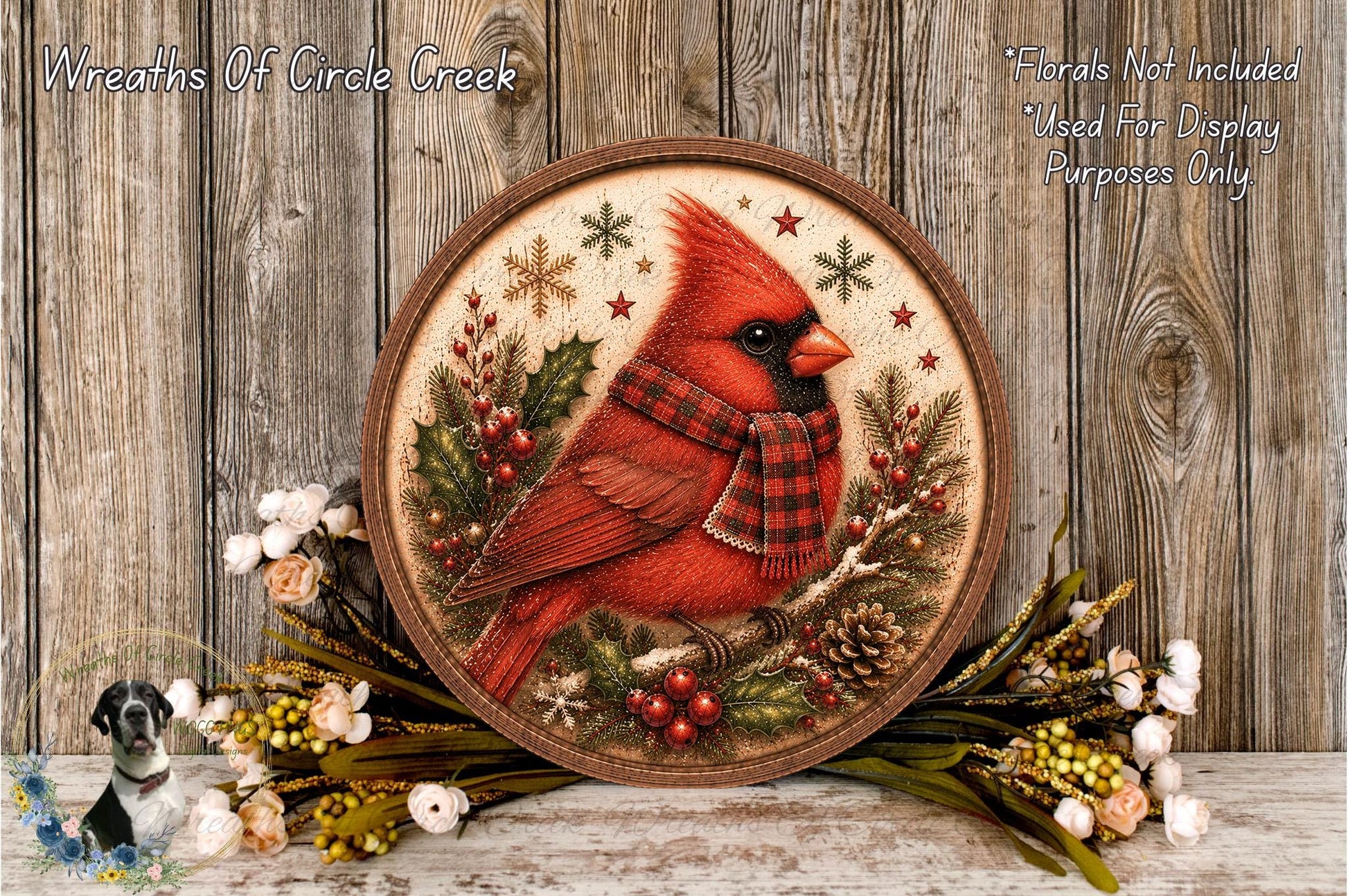 A round wooden plaque featuring a red cardinal bird, surrounded by holiday decorations such as pine cones, berries, and flowers, against a wooden background.