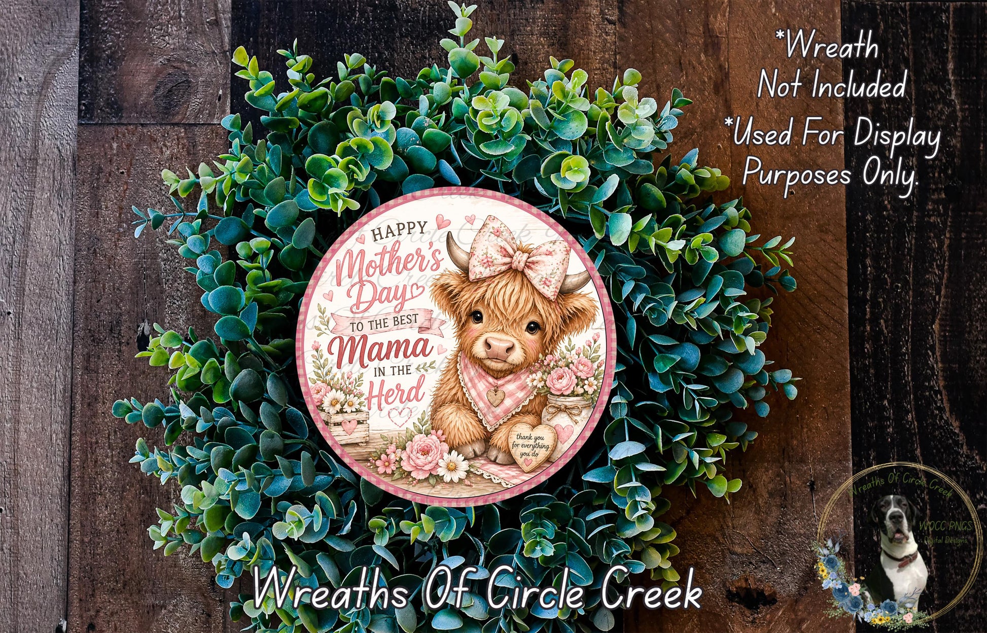 A wreath made of green leaves and flowers, with a circular design featuring a cow and the text "Happy Mother's Day to the best Mama in the herd".