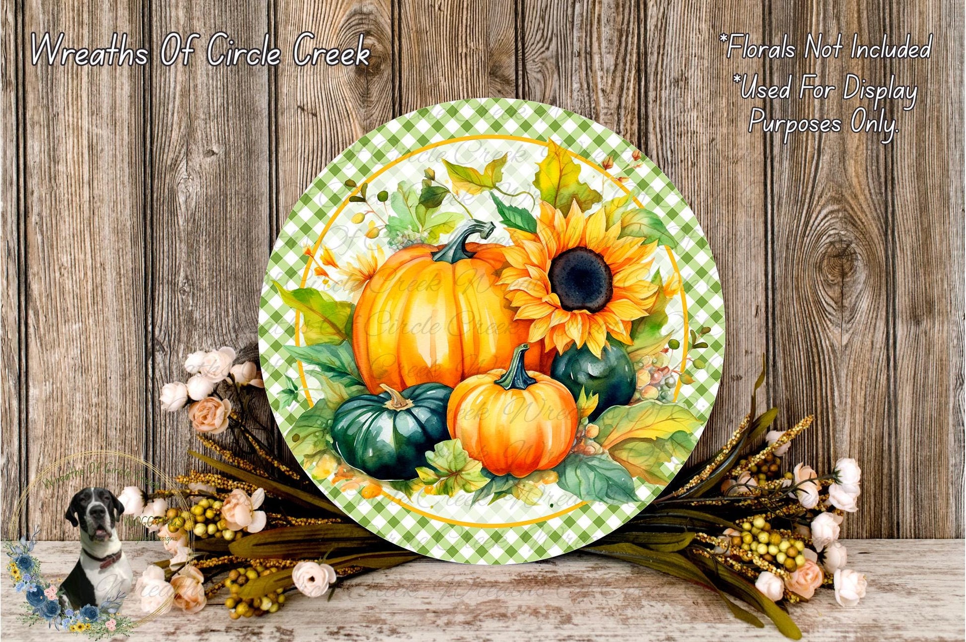 a round decorative plate with a vibrant autumnal design, including pumpkins, sunflowers, and other fall foliage. The plate is placed on a wooden surface, surrounded by a floral arrangement and some flowers.