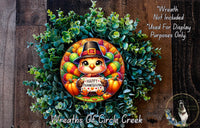 A wreath made of green leaves and colorful autumn-themed elements, including a small turkey wearing a witch's hat and holding a sign that says "Happy Thanksgiving".
