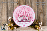 a round sign with three pink gnomes holding pink roses, surrounded by pink flowers and greenery. The sign has the text "Pink Squad" written on it.