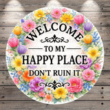 A circular sign with a floral border and the text "Welcome to my happy place don't ruin it" written on it.
