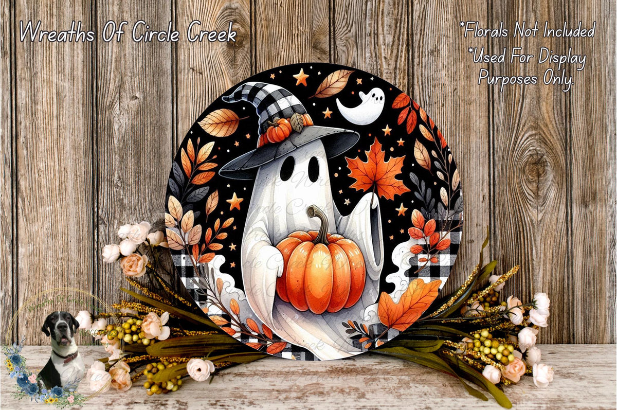 A Halloween-themed wreath featuring a ghost holding a pumpkin, surrounded by autumn leaves, flowers, and a witch's hat.