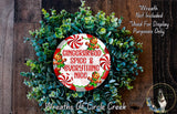 A wreath made of green leaves and red and white candy canes, with a red and white circular sign that says "Gingerbread Spice & Everything Nice" in the center.