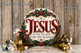 a circular sign with the text "JESUS IS THE REASON FOR THE SEASON" surrounded by a wreath of holly, berries, and other holiday decorations. The sign is placed on a wooden surface, and there are additional floral arrangements in the background.