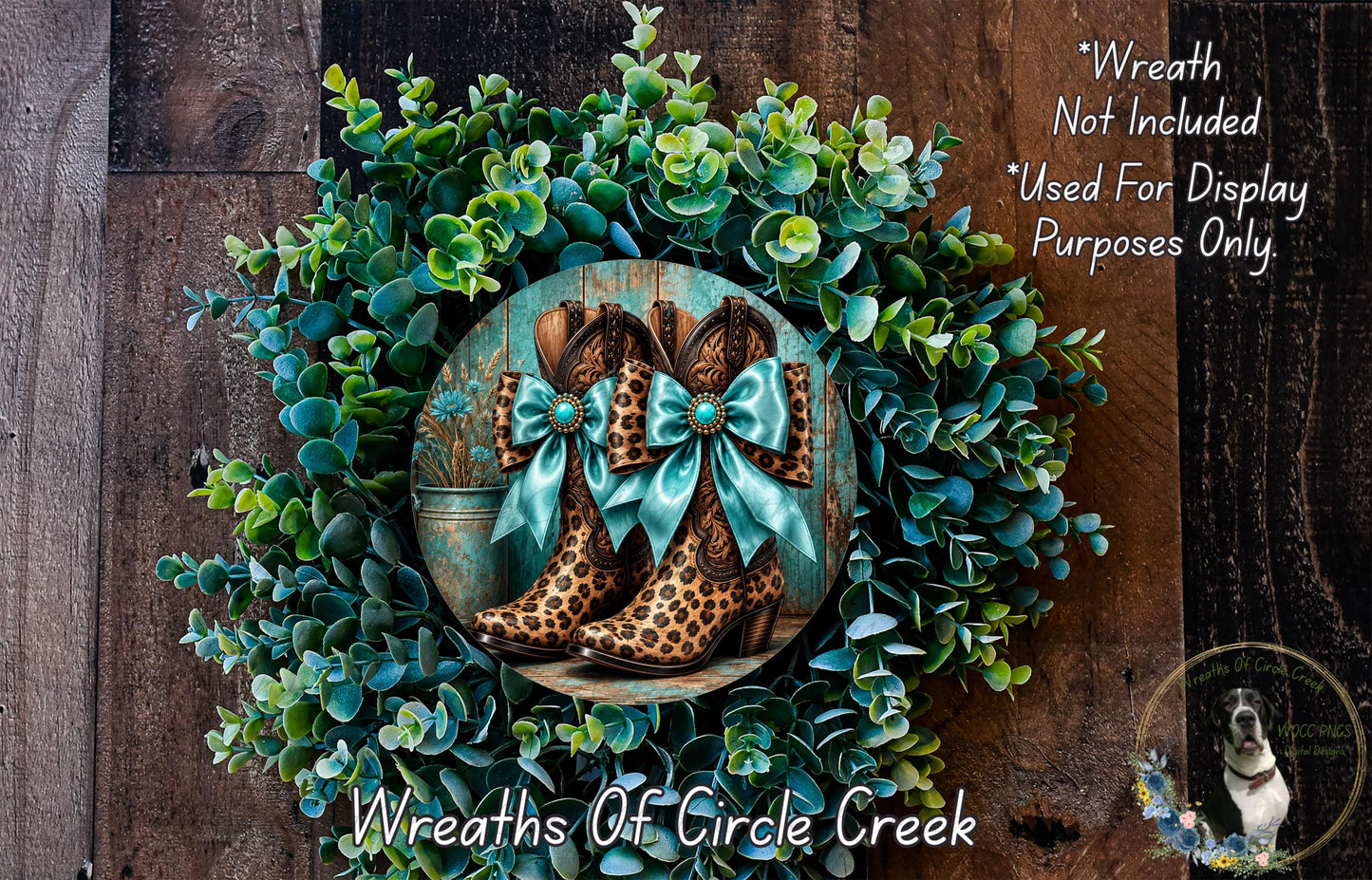 A wreath made of green foliage and brown leopard-print boots with blue bows, displayed on a wooden surface.