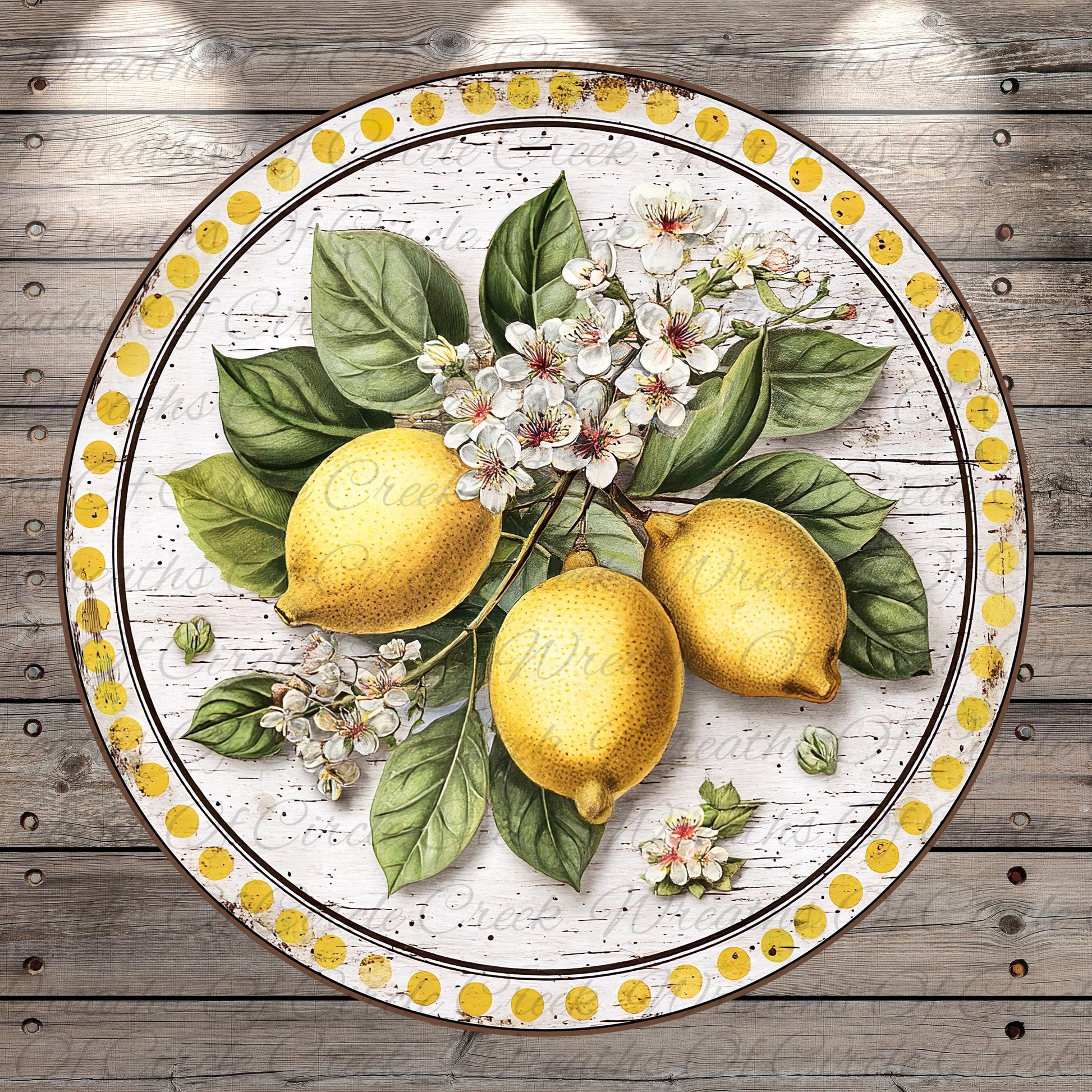 A circular arrangement of three lemons, leaves, and flowers on a wooden surface.