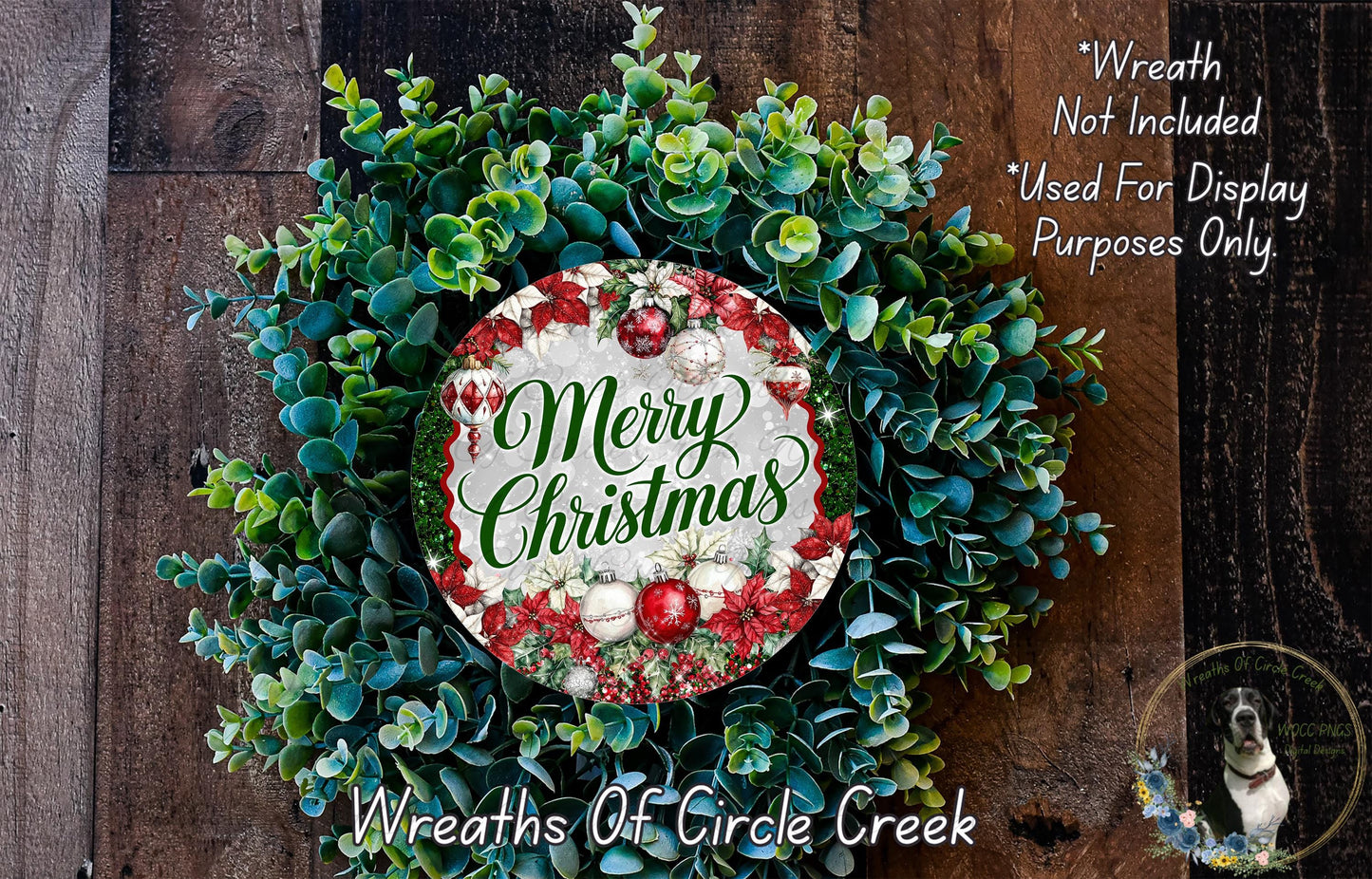 A wreath made of various green and red foliage, with a circular sign in the center that reads "Merry Christmas". The wreath is displayed on a wooden surface, and there is a text overlay that says "Wreath Not Included * Used For Display Purposes Only".