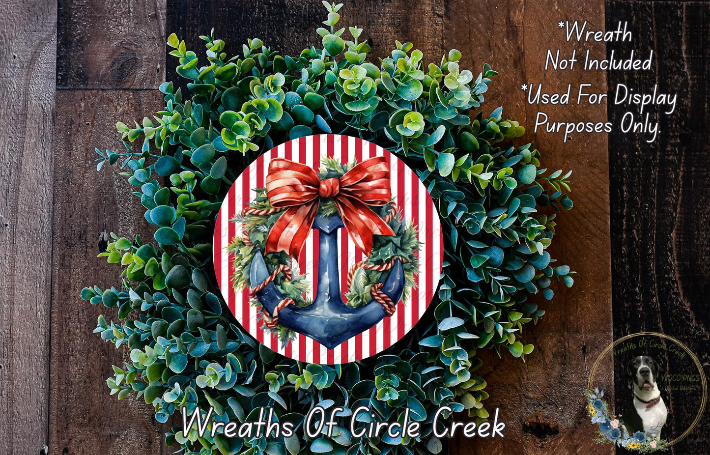 A wreath made of green leaves and a red and white striped anchor, with a red ribbon bow, is displayed on a wooden surface.