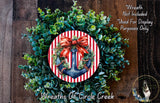 A wreath made of green leaves and a red and white striped anchor, with a red ribbon bow, is displayed on a wooden surface.
