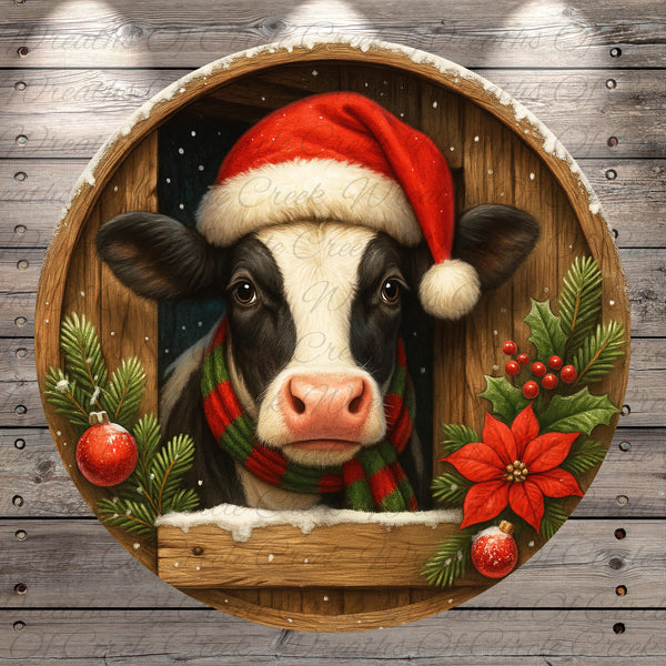 A black and white cow wearing a Santa hat and scarf peeks out from behind a wooden frame adorned with Christmas decorations, including poinsettias and ornaments.