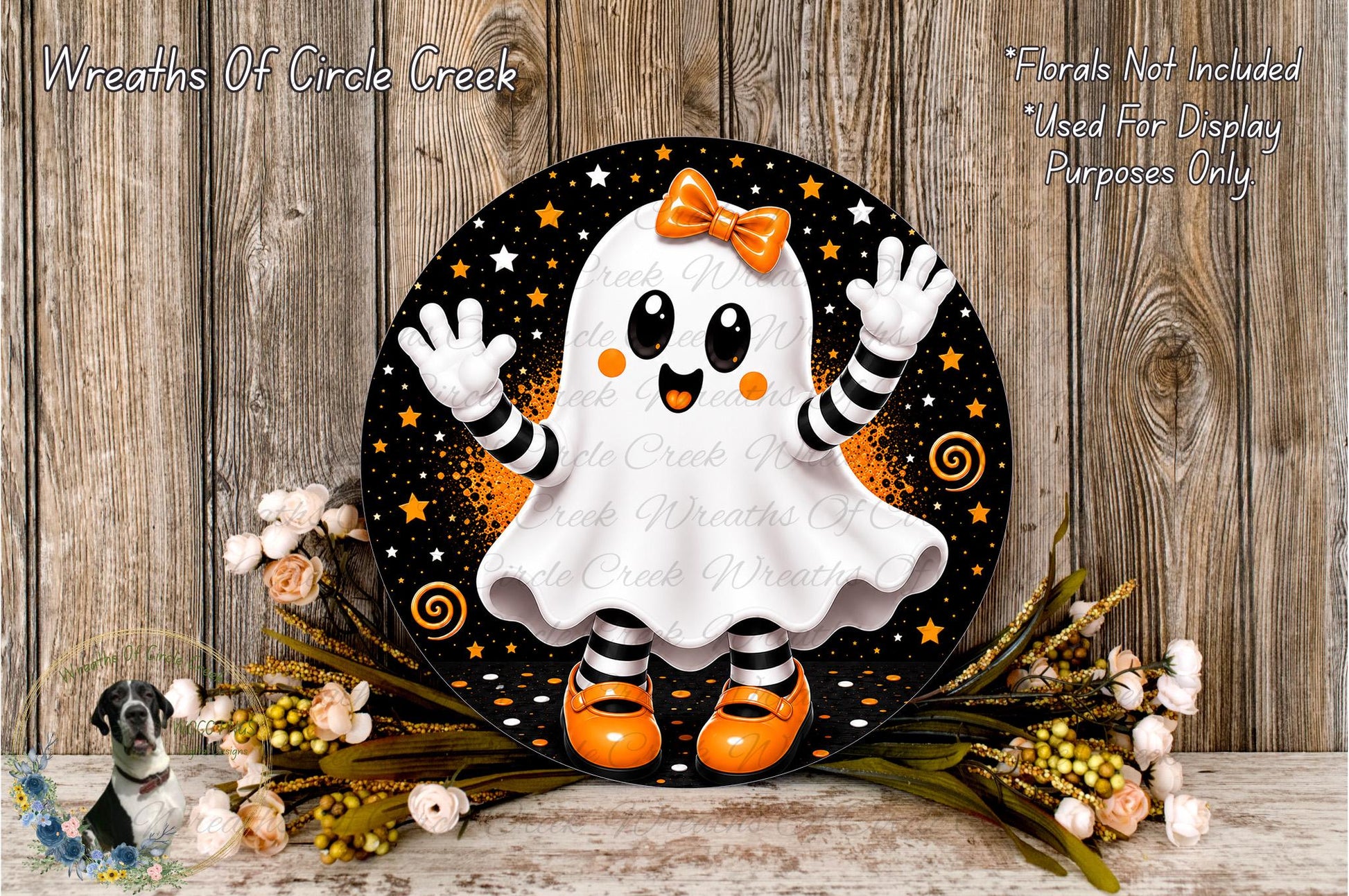 A Halloween-themed wreath featuring a ghost character with a bow, surrounded by flowers and placed on a wooden surface.