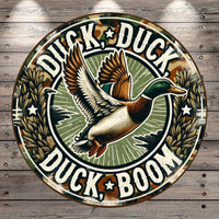 A circular sign featuring a cartoon duck in flight with the text "Duck, Duck, Boom" around it.