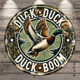 A circular sign featuring a cartoon duck in flight with the text "Duck, Duck, Boom" around it.