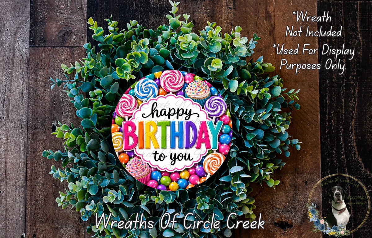 A colorful birthday wreath made of greenery and adorned with candy and cupcakes, featuring the text "Happy Birthday to you" in a vibrant design.