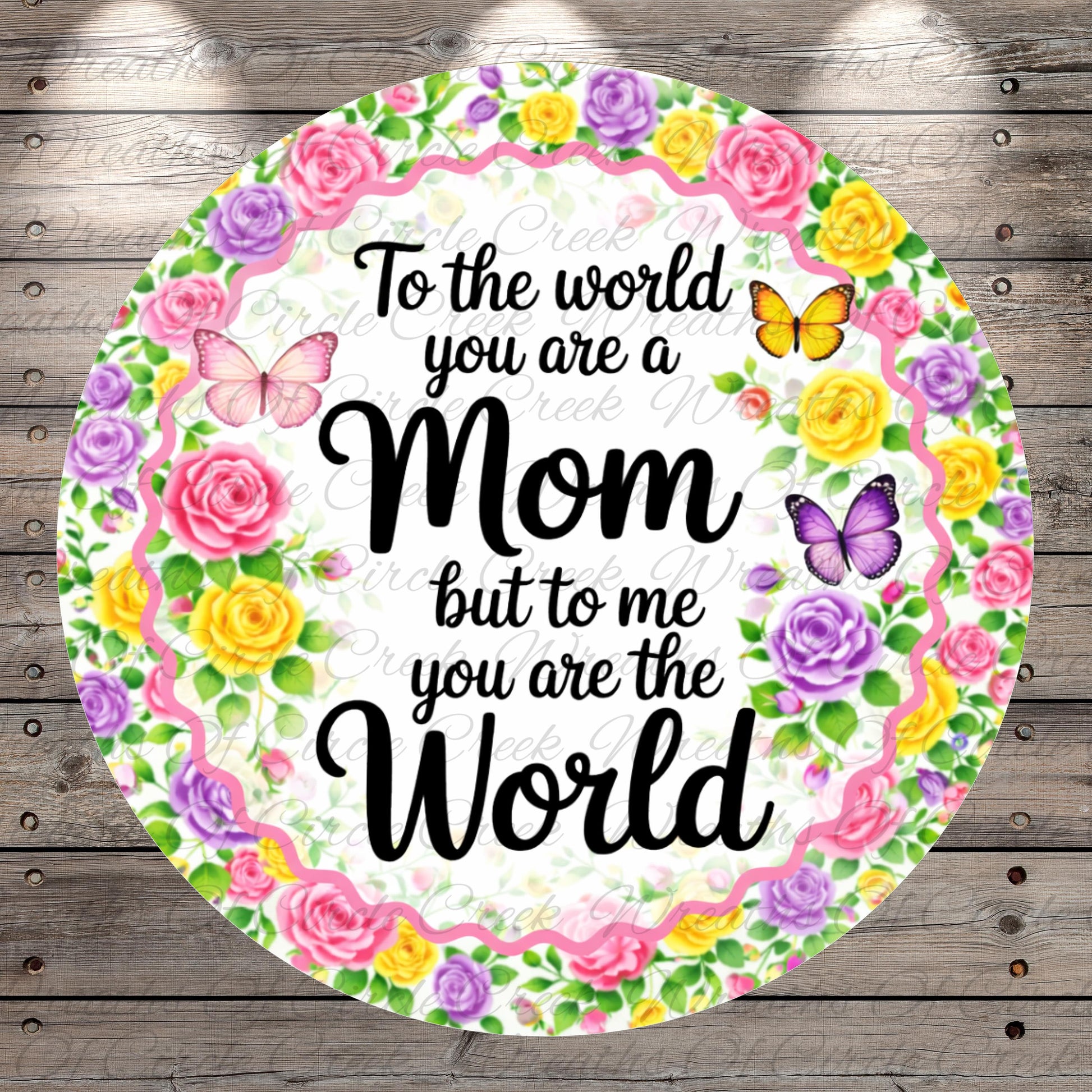 A round floral wreath with a message that reads "To the world you are a Mom but to me you are the World" surrounded by colorful flowers and butterflies.