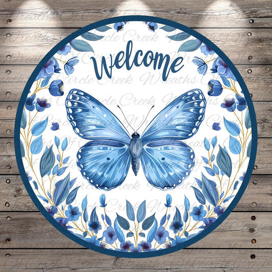 a circular sign with a blue butterfly and blue flowers, surrounded by a wreath of blue flowers and leaves. The sign has the word "Welcome" written on it.