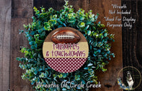 a wreath made of green foliage and a football, with the text "Tailgates & Touchdowns" displayed on it.